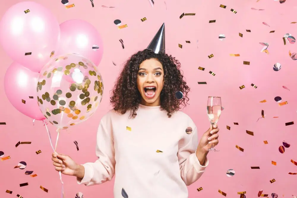 Black woman celebrating her birthday with birthday freebies 