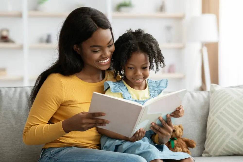Black mom reading with her daughter before checking out kids eat free deals