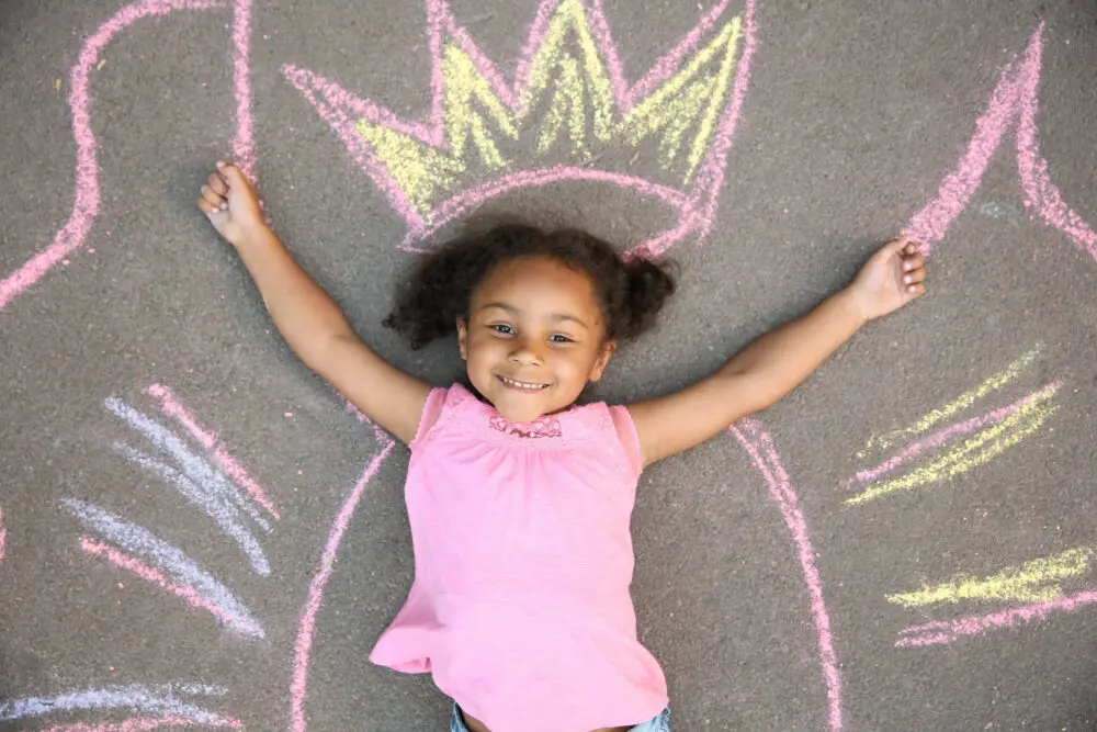 Black girl laying in chalk drawing