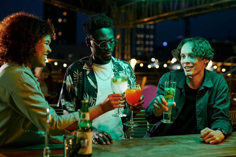 three friends enjoying cocktails in a black-owned lounge