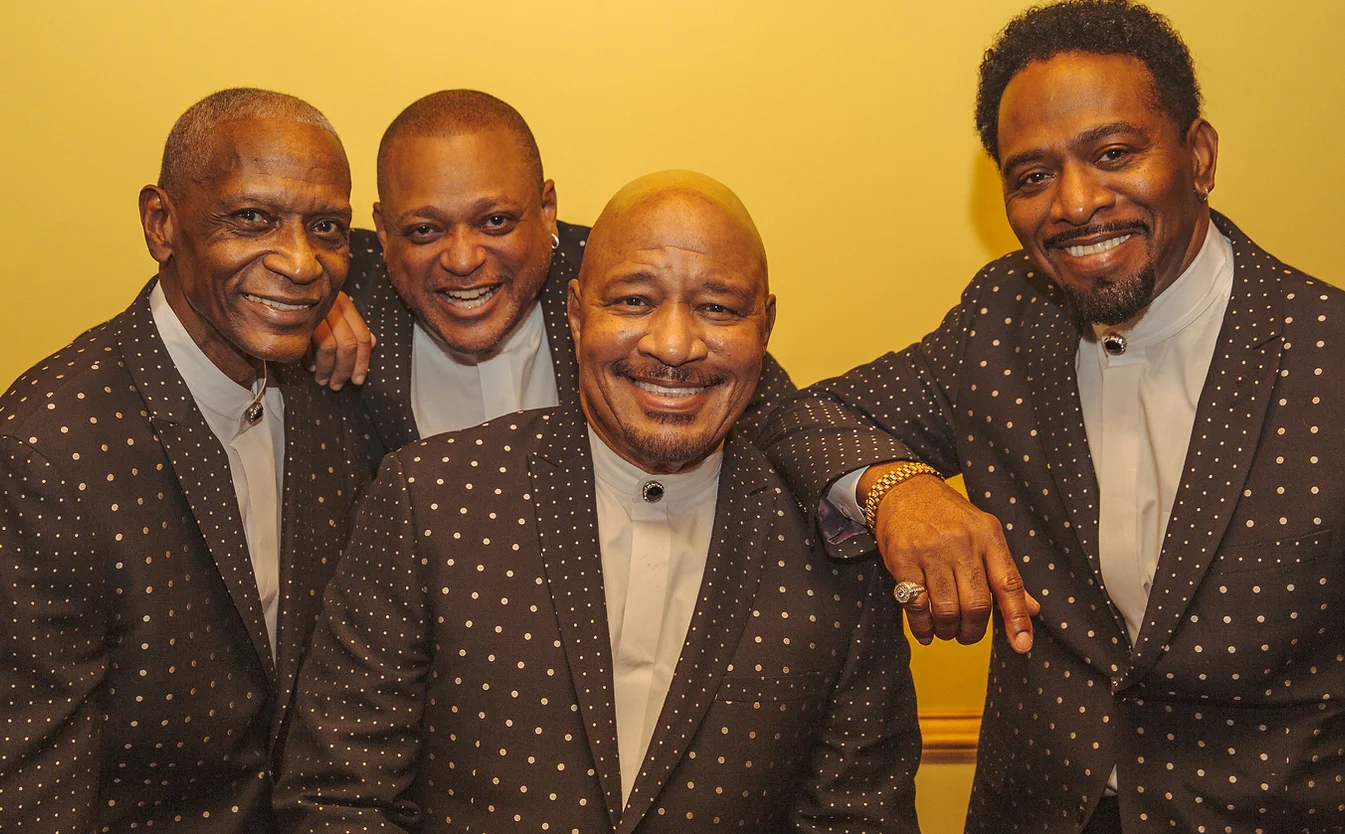The Stylistics pose for a photo in matching suits.