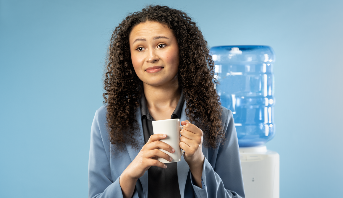 Origin Story Promotional Photo of Margaret (Amira Danan) in front of a water cooler